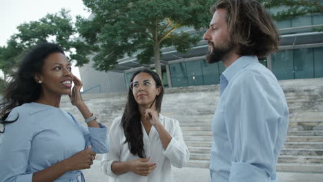 three people standing outside office building and communicating