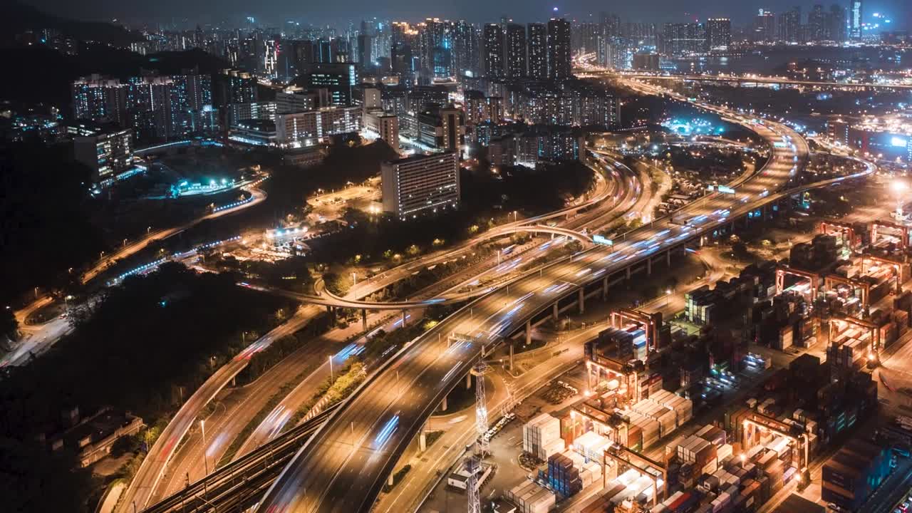Urban aerial drone time lapse in motion or hyperlapse at night flying along an interstate with traffic showing the on and off ramp circles. Bird view of traffic at night at Lai King, Hong Kong