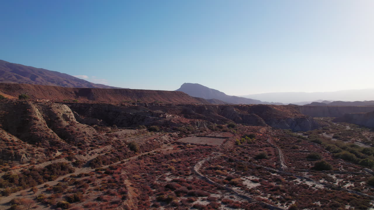 Birdseye view of Tabernas Desert in Almeria, Spain, tilting up to reveal the empty landscape during sunset