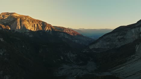 Drone-view-on-dolomites-valley,-dark-pine-forest-early-in-the-morning-in-winter-season