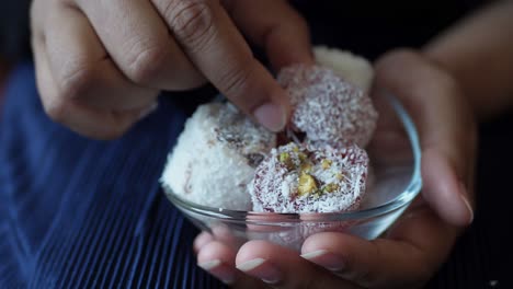 a hand picking up a turkish delight with pistachio