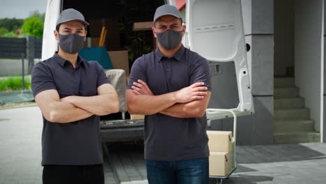 Video-portrait-of-two-delivery-men-standing-in-protective-mask
