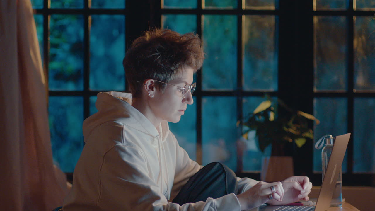 Young Woman Working on Laptop at Night before the Deadline