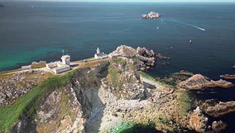 downward dolly aerial view of a lighthouse on the rugged coast