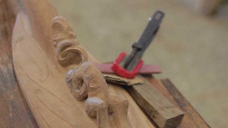 closeup in slow motion of wood carving a maori element in a woodshop