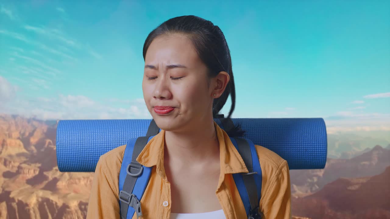 Close Up Of Asian Female Hiker With Mountaineering Backpack Shaking Her Head And Making Unsatisfied Face While Traveling At The Top Of Mountain