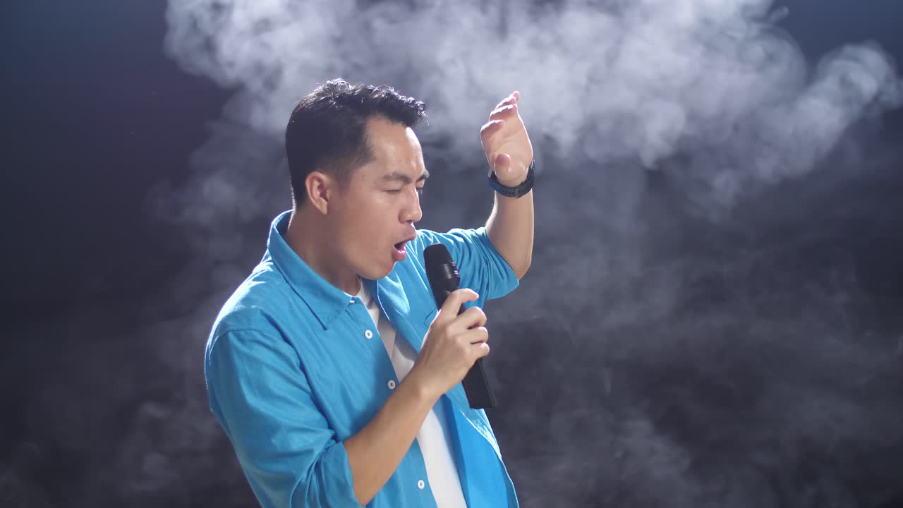 연기 배경으로 마이크에 노래하는 남자