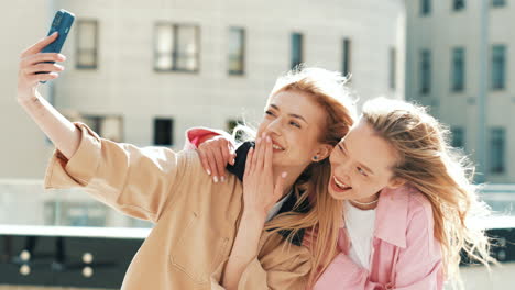 two friends taking a selfie outdoors