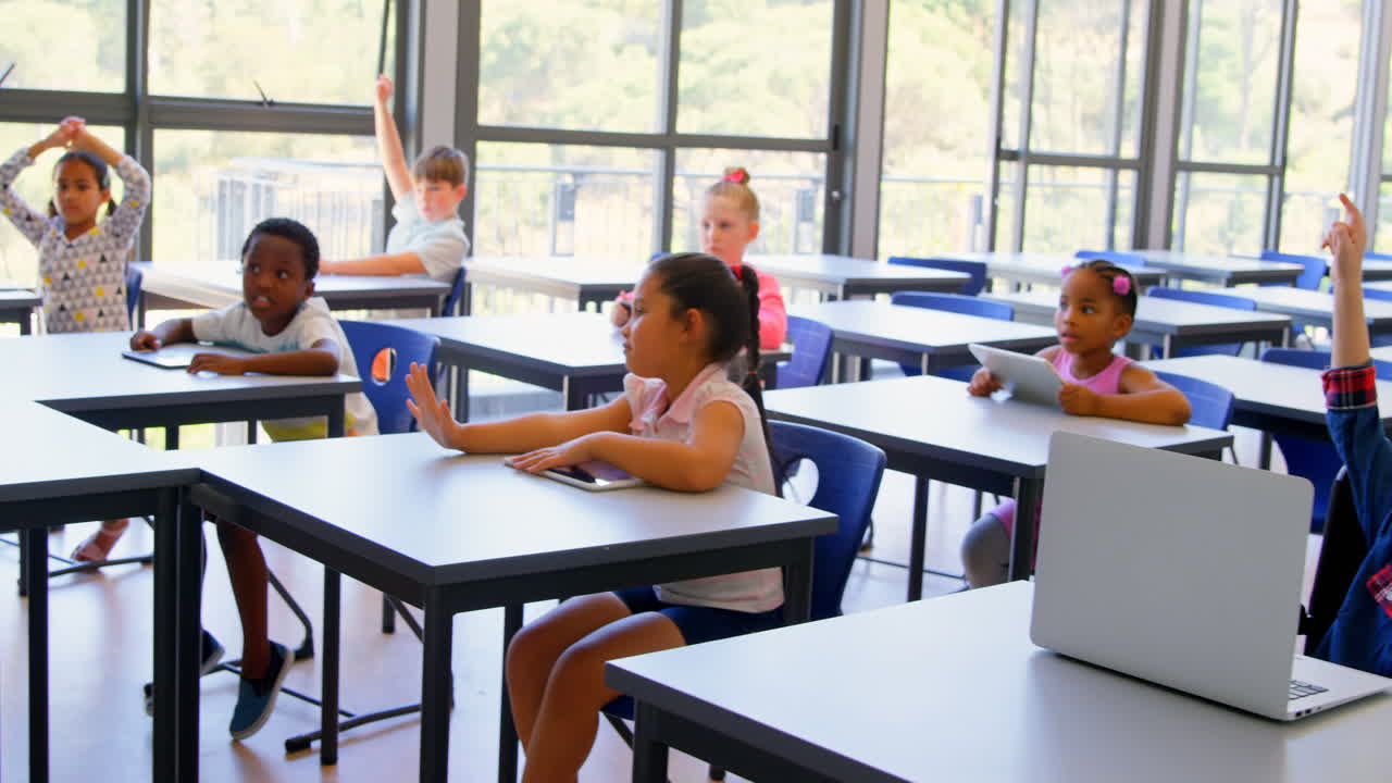 Scolari che alzano le mani in classe a scuola 4k