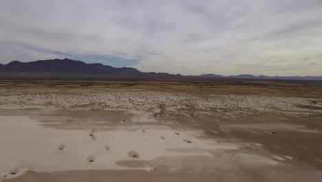 Environmental-destruction-on-Willcox-Playa,-a-dry-lakebed-in-Arizona,-aerial-backwards-panning