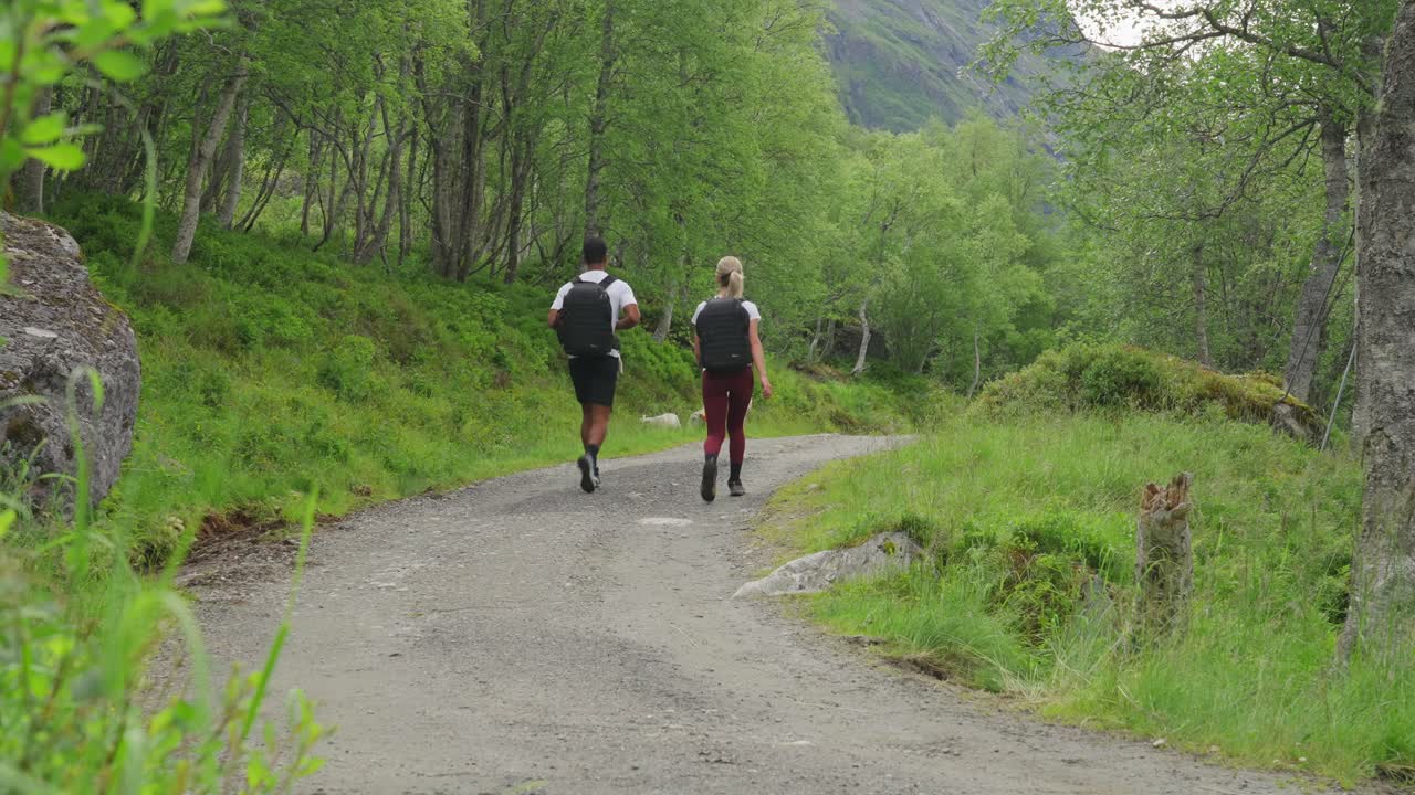 Couple Hiking on a Forest Path with Sheep in a Mountainous Landscape