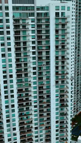 multi-apartment high-rise building in the residential area. miami downtown block of flats from top view. vertical video
