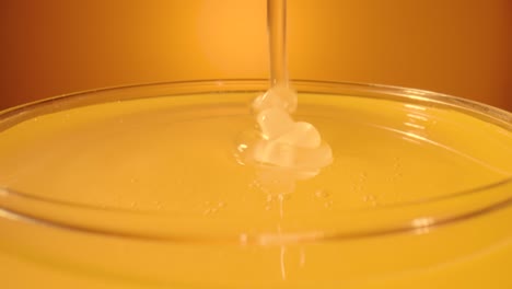 honey dripping into a glass bowl