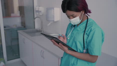 una joven doctora con mascarilla consulta algunos resultados médicos