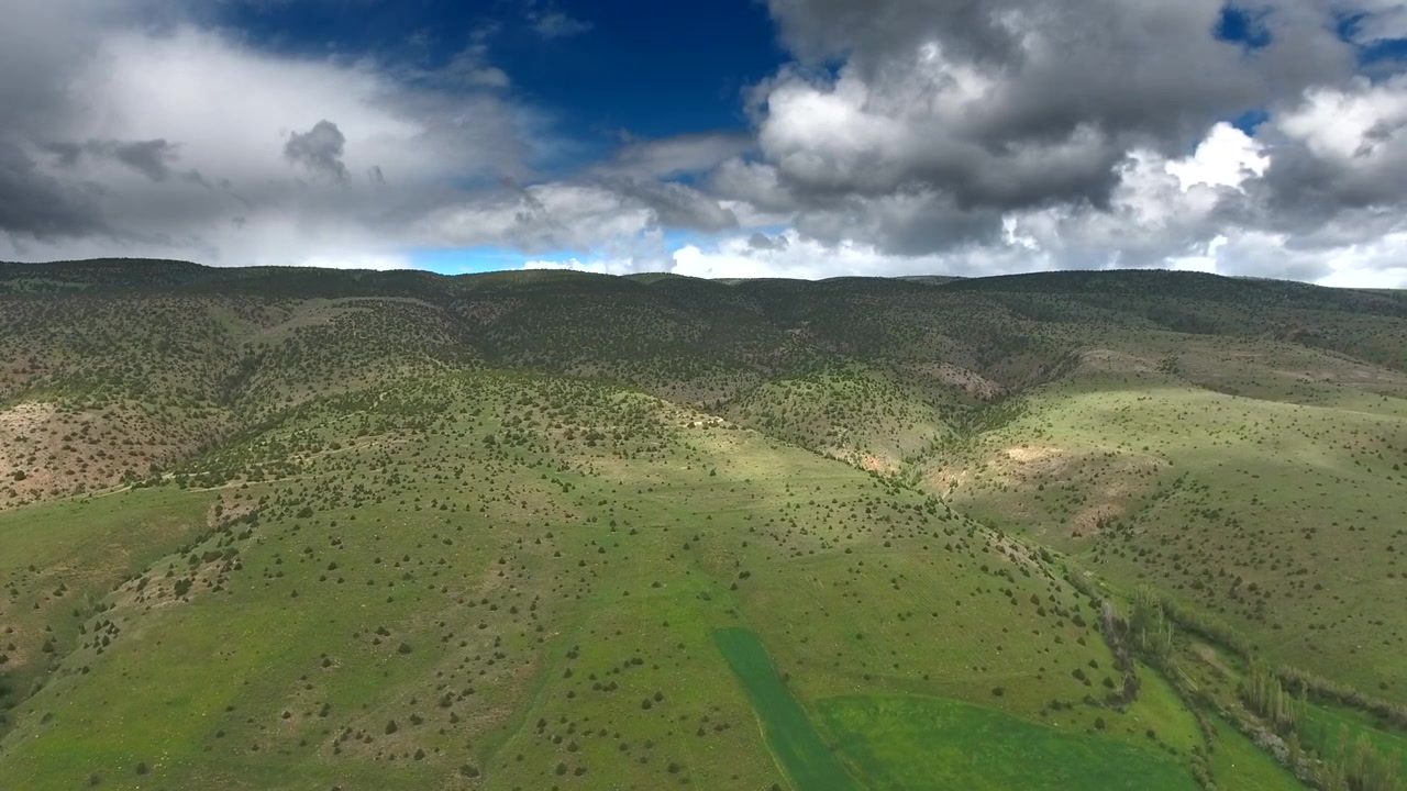 Vista aerea di dolci colline verdi e cielo nuvoloso