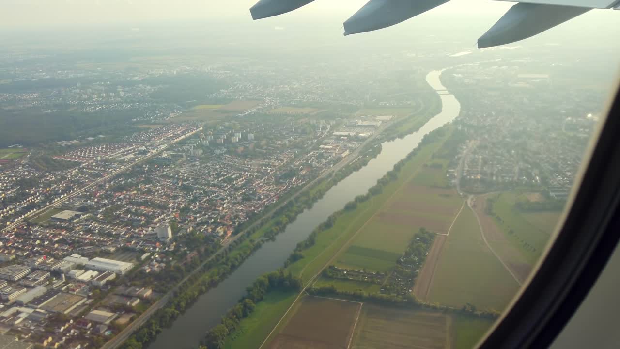 A beautiful aerial view shows a river winding through a city and surrounding countryside during sunset. Looks peaceful and offers a glimpse of urban and rural life