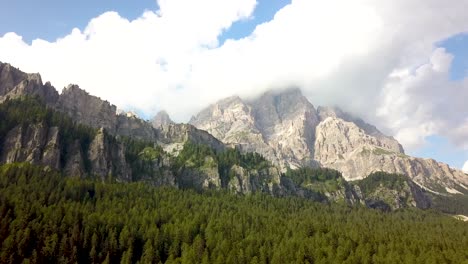 Volando-Por-La-Cresta-De-Una-Montaña,-Cubierta-De-Pinos-Verdes-En-Un-Acantilado-En-El-Valle-Cerca-Del-Parque-Nacional-Tre-Cime,-Dolomitas,-Alpes,-Italia