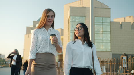 businesswomen walking and talking outdoors