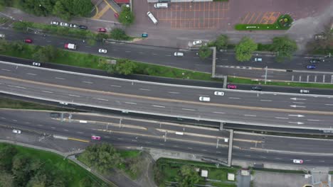 tracking aerial flight directly above traffic and white car speeding and traveling on mexico city periferico sur expressway, mexico, overhead drone sideways