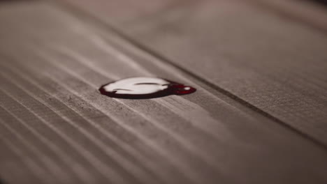 droplets of red blood on wooden table