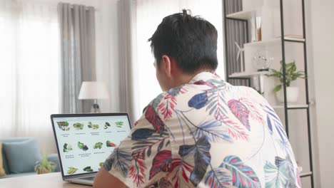 Asian Man Using Laptop Computer Buys In Internet Shop. Male Selects Vegetables In Grocery Online Store