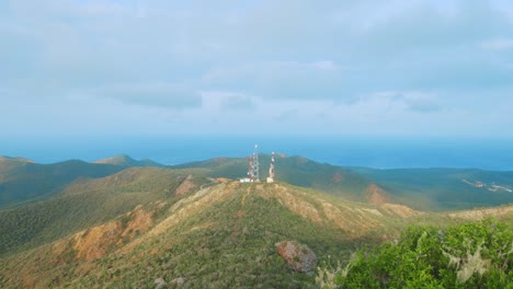 torres celulares en la cima de una colina distante en curacao, caribe con nubes de tormenta reunidas