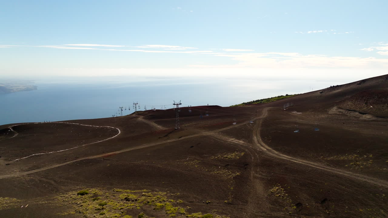 Drone glides above barren cliffs and ski lift in Osorno, Chile