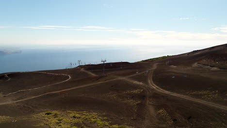 drone glides above barren cliffs and ski lift in osorno, chile