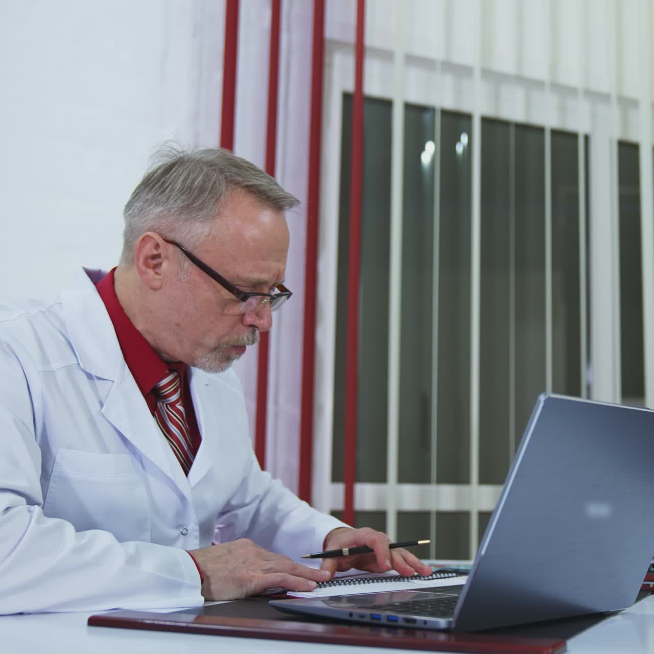 Doctor chatting with patients online, using laptop at his workplace. Telemedicine concept