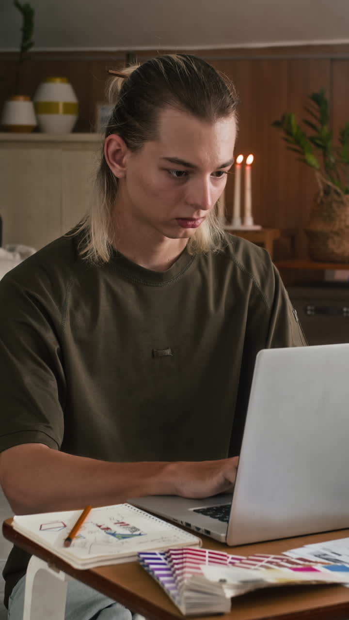 Vertical of Designer Using Laptop at Small Fashion Studio
