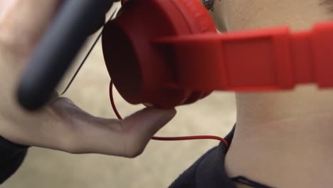 Woman-puts-on-headphones,-then-looks-and-touches-the-mobile-screen