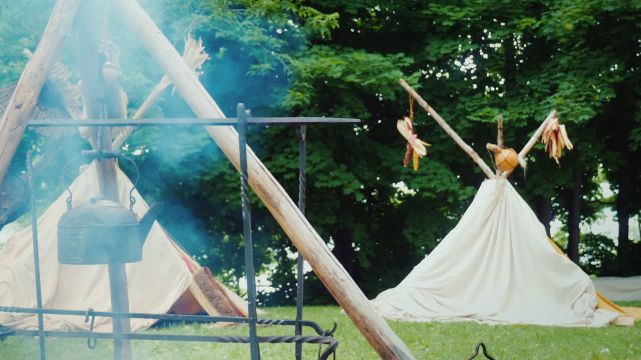 숲 음식에 있는 아메리카 원주민 캠프가 전경 전통 wigwam 텐트에서 준비되고 있습니다.