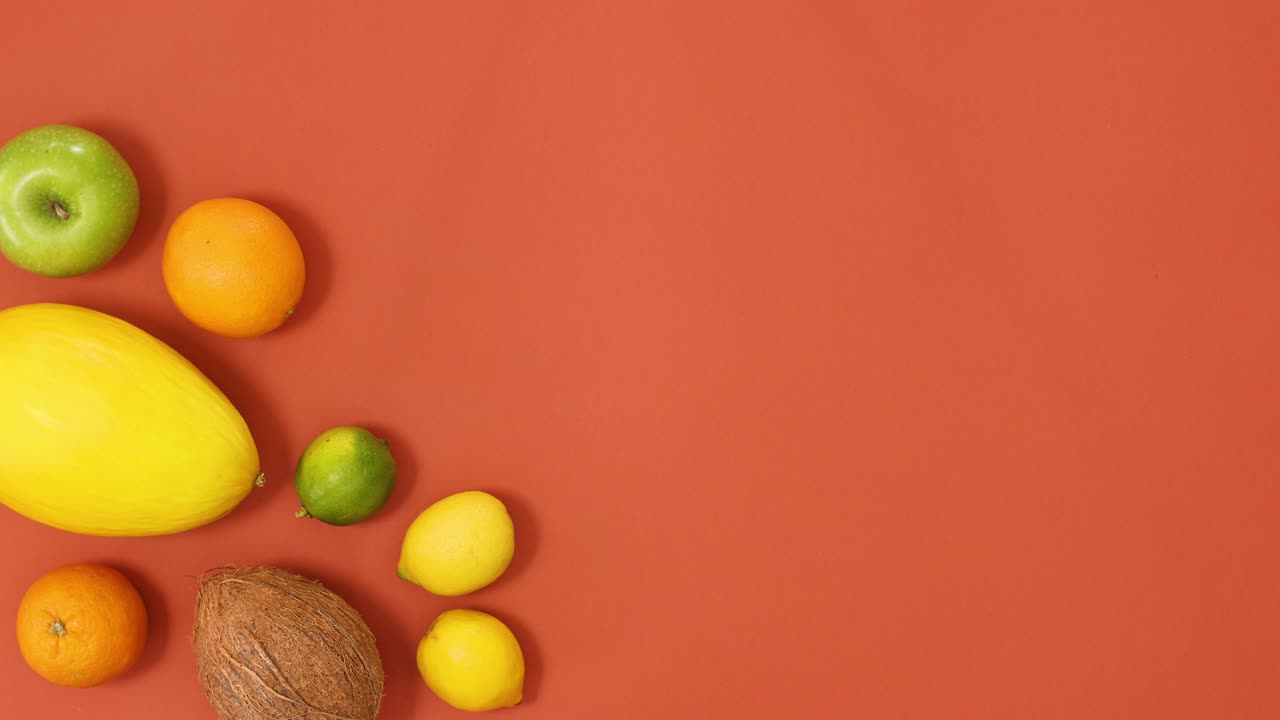 las frutas tropicales de verano hacen un diseño creativo en el lado izquierdo del fondo naranja.