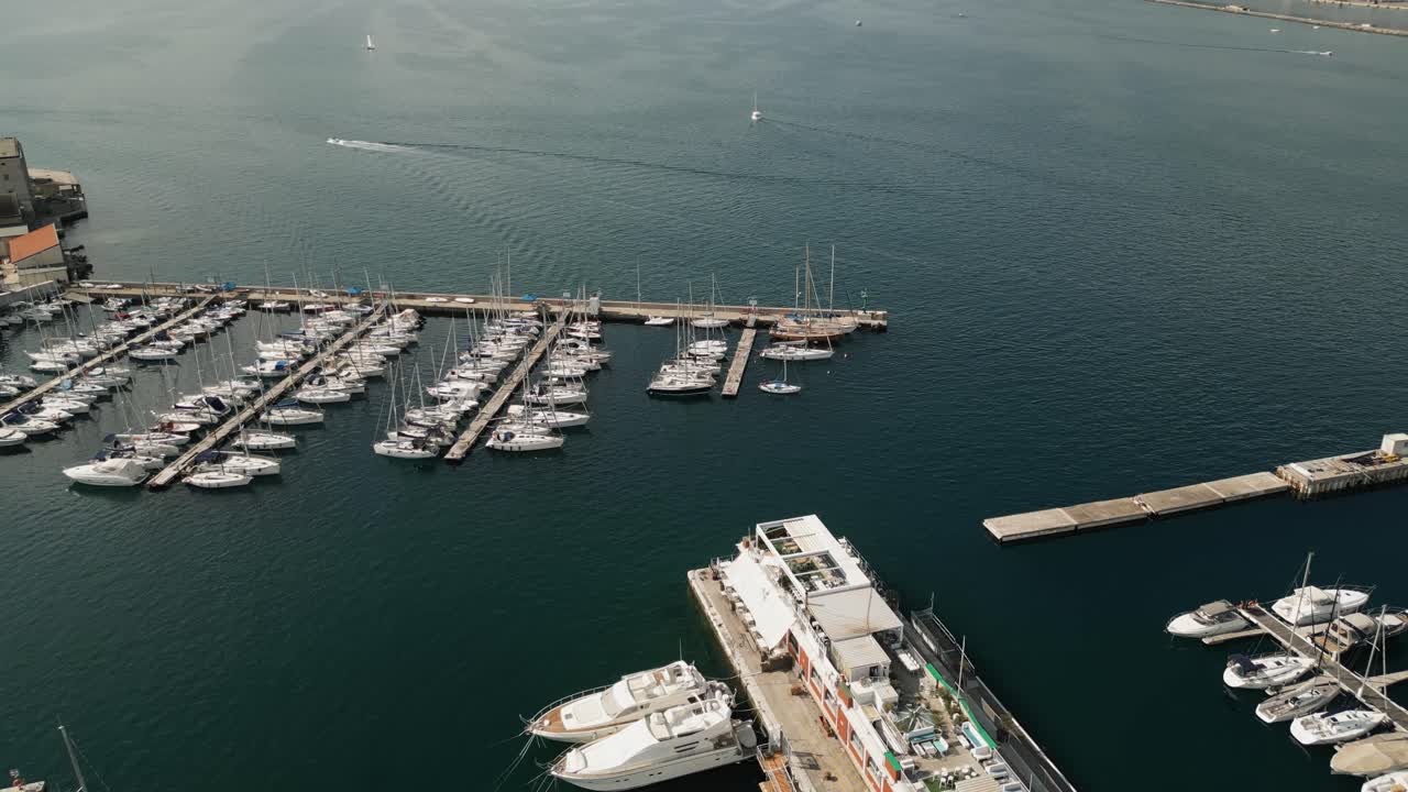 Vista aérea de una marina con veleros y paisaje urbano