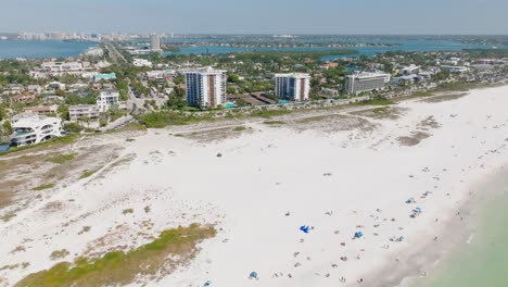 multi-angle aerial view of people on a florida beach with city skyline in the background