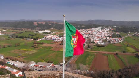 close up of portugal flag flying on top of castle of aljezur