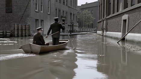 men rowing a boat through a flooded city street
