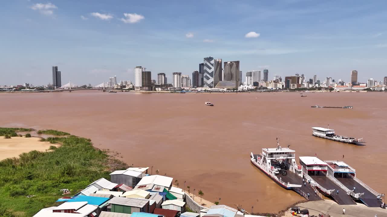Drone hyperlapse above the Mekong river showing boats activities and ferries crossing from side to side to Phnom Penh city, Cambodia