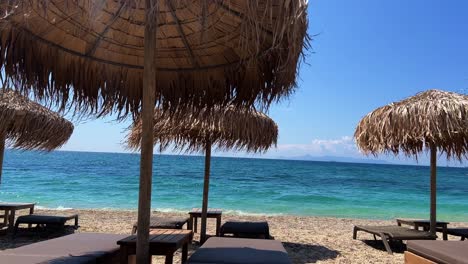 aegean sea with sun beds and light waves in athens during the summer