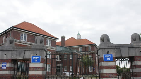 asylum mental hospital building with gates entrance establishing shot