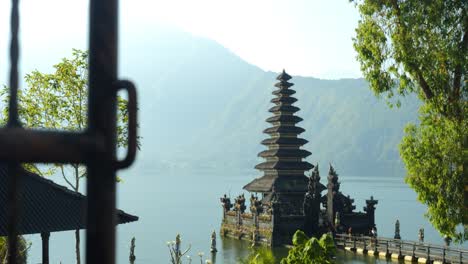 slow motion panning shot of pura segara ulun danu batur a historical temple at volcanic lake batur on a sunny day during the beautiful summer trip through bali indonesia