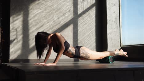 woman doing yoga stretches with foam roller