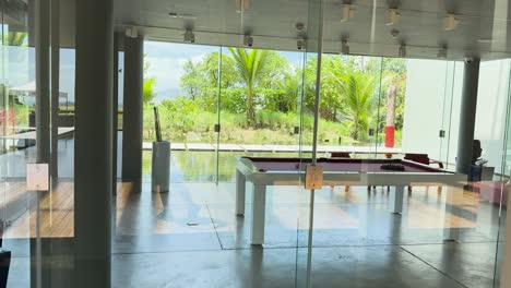 a tranquil view of a luxury resort in phuket, thailand, showcasing modern architecture and lush greenery through large glass windows