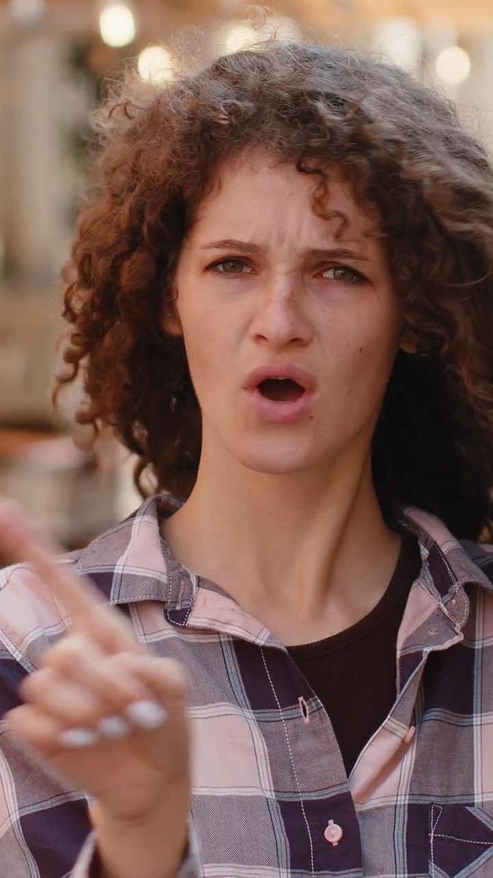 Giovane donna scontenta e turbata che reagisce a un'idea spiacevole e terribile, agitando la mano, il dito e scuotendo la testa in segno di diniego.