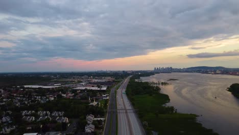 Dramatischer-Sonnenuntergang,-Während-Die-Autobahn-Zu-Wolkenkratzern-Am-Horizont-Führt,-Montreal