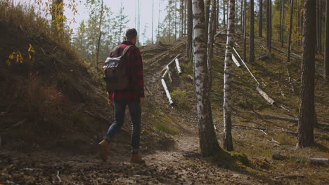 Outdoor-Aktivitäten,-Reisekonzept,-Mensch-In-Der-Natur.-Rückansicht-Einer-Gehenden-Person-Auf-Einer-Feldstraße-Im-Nationalpark.-Ein-30er-Jahre-Tourist-Geht-Auf-Einer-Abenteuerreise-In-Die-Naturlandschaft-Und-Wandert-In-Einer-Umgebung.-Hochwertiges-4K-Filmmaterial