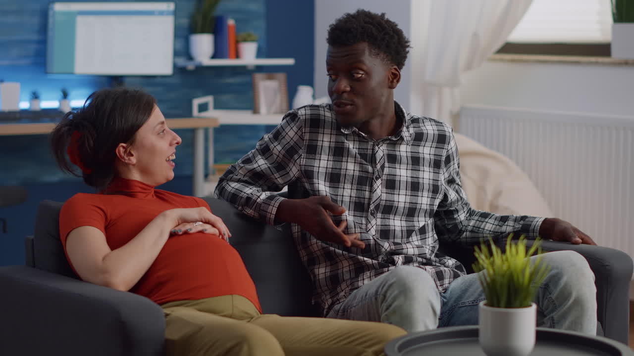 Interracial couple expecting child in living room