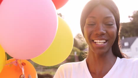 Portrait-of-attractive-woman-is-smiling-and-holding-balloon