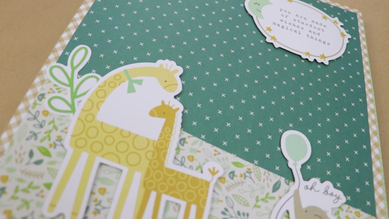 Adorabile album scrapbook a tema neonato con decorazioni di giraffa ed elefante, perfetto per catturare i ricordi.