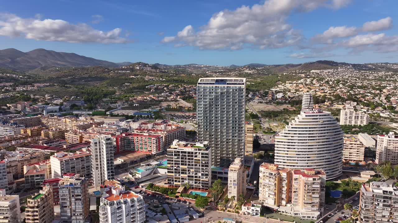 Aerial view captured by drone of Calpe beach promenade with high-rise buildings.